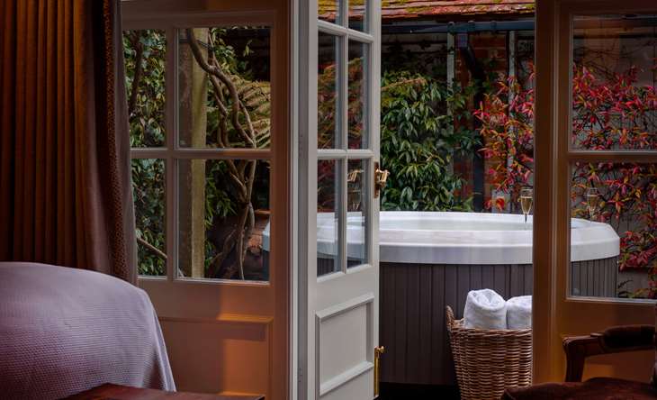 Outdoor hot tub viewed through French doors.