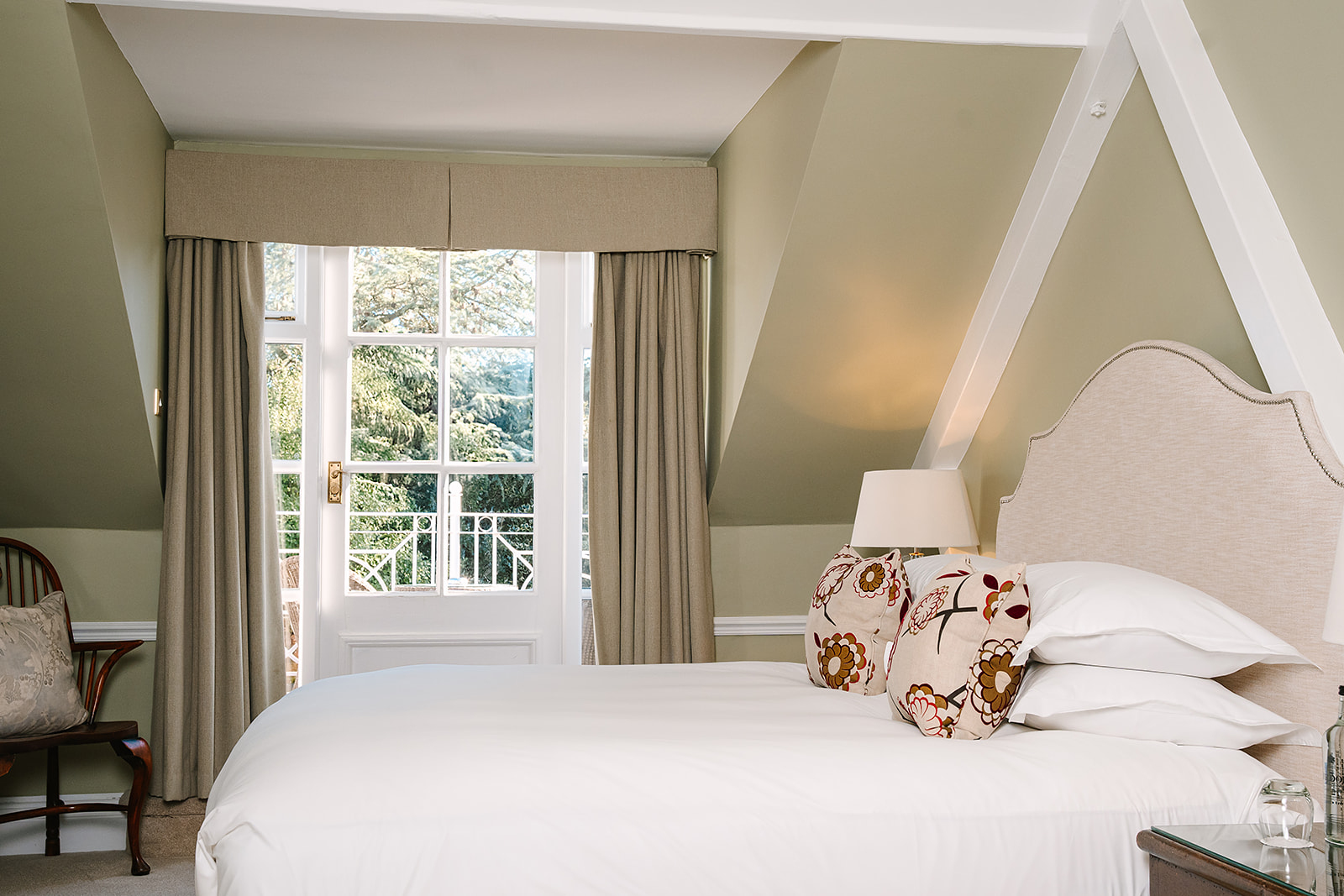 Attic-style bedroom with white bed and balcony.