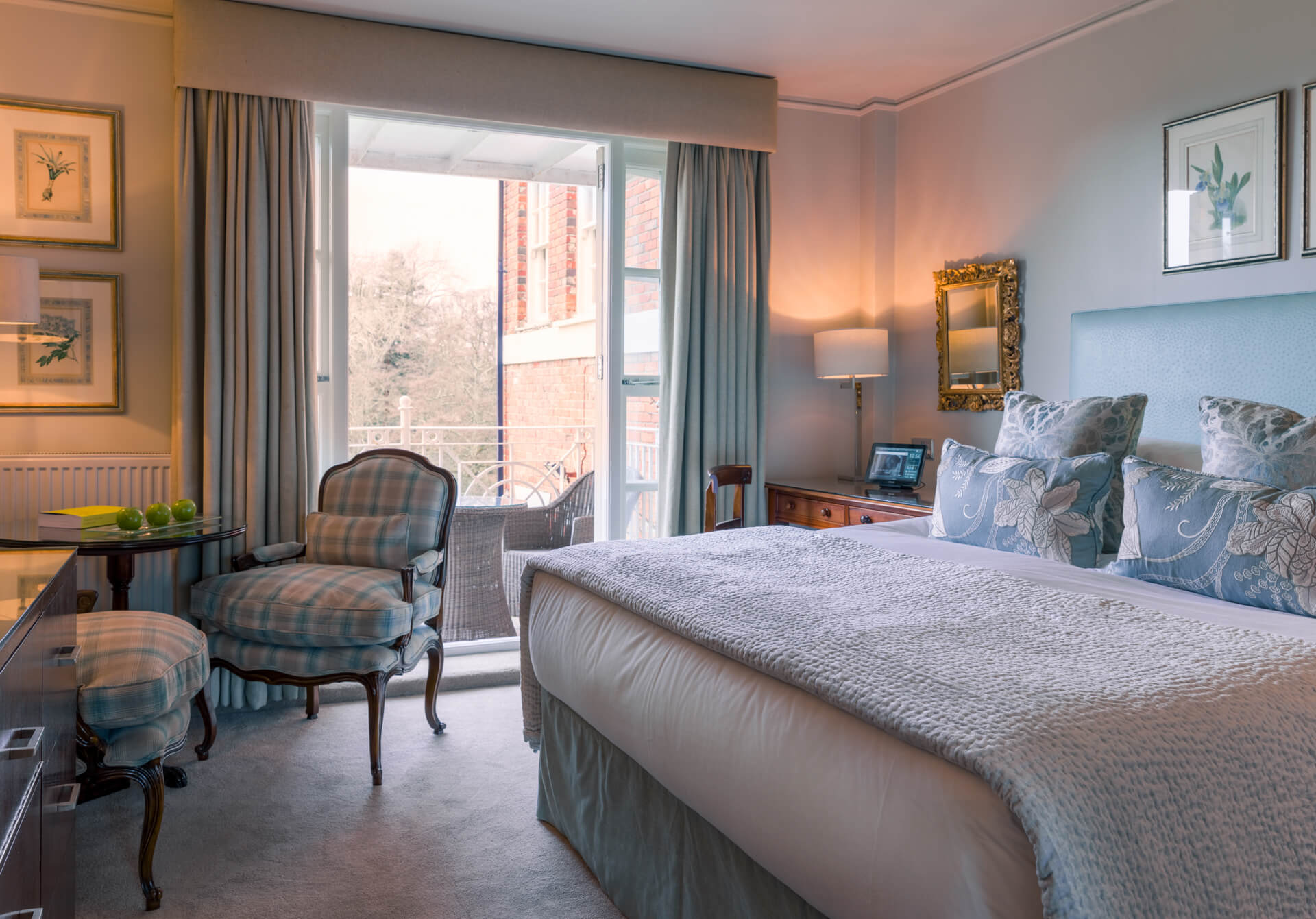 Elegant bedroom with balcony and floral armchair.