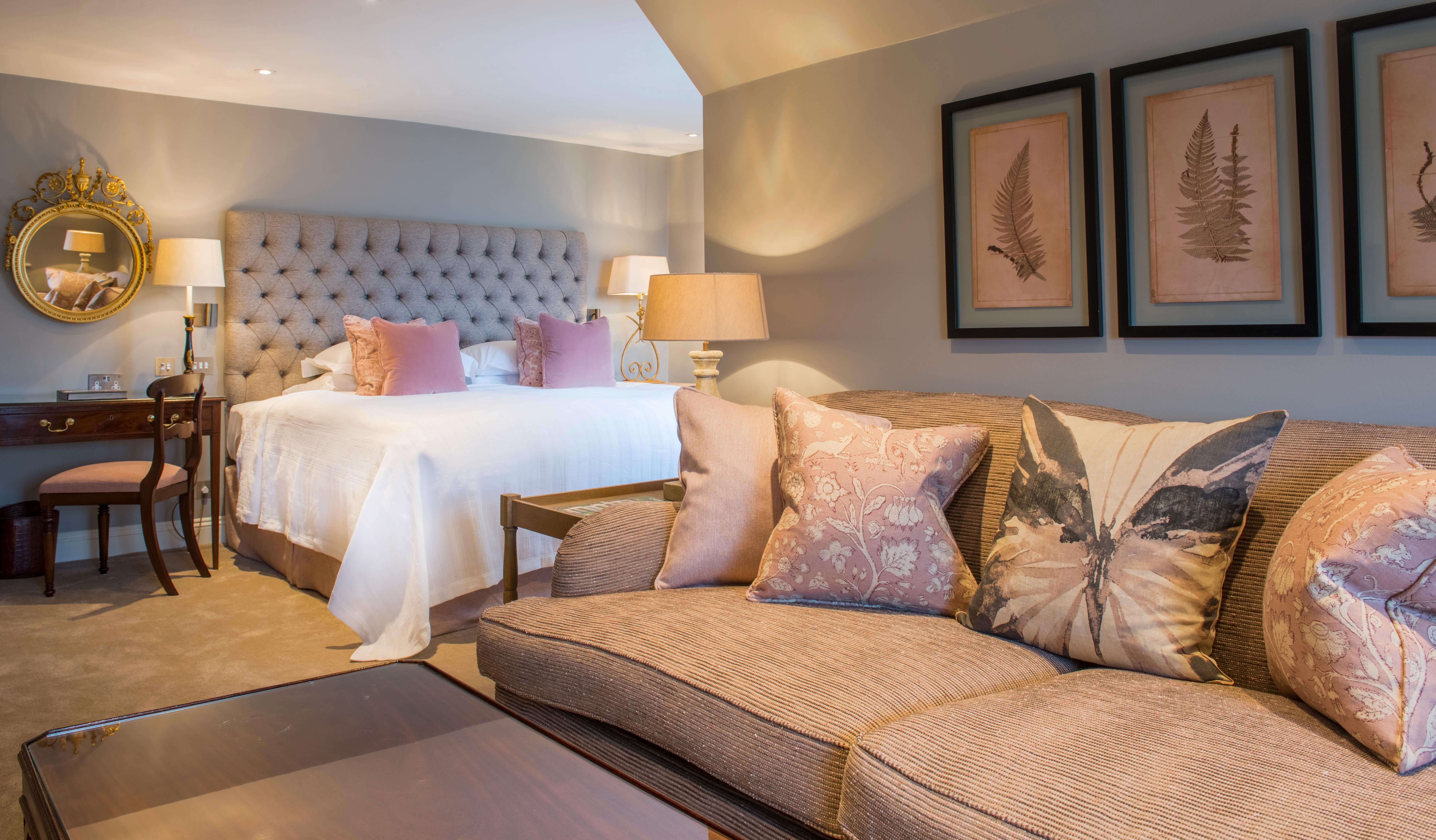 Cosy bedroom with sofa and pastel cushions.